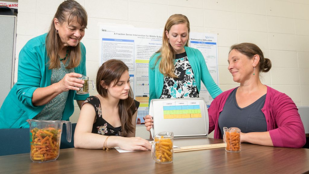 The Fractions Sense intervention team discusses classroom tools in their Fractions Lab.