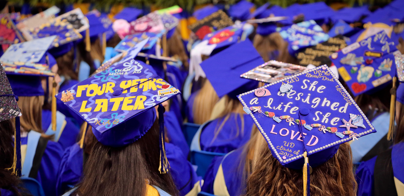 This image shows an aerial view of the decorated graduation caps of undergraduate students in the College of Education and Human Development during the college convocation ceremony.