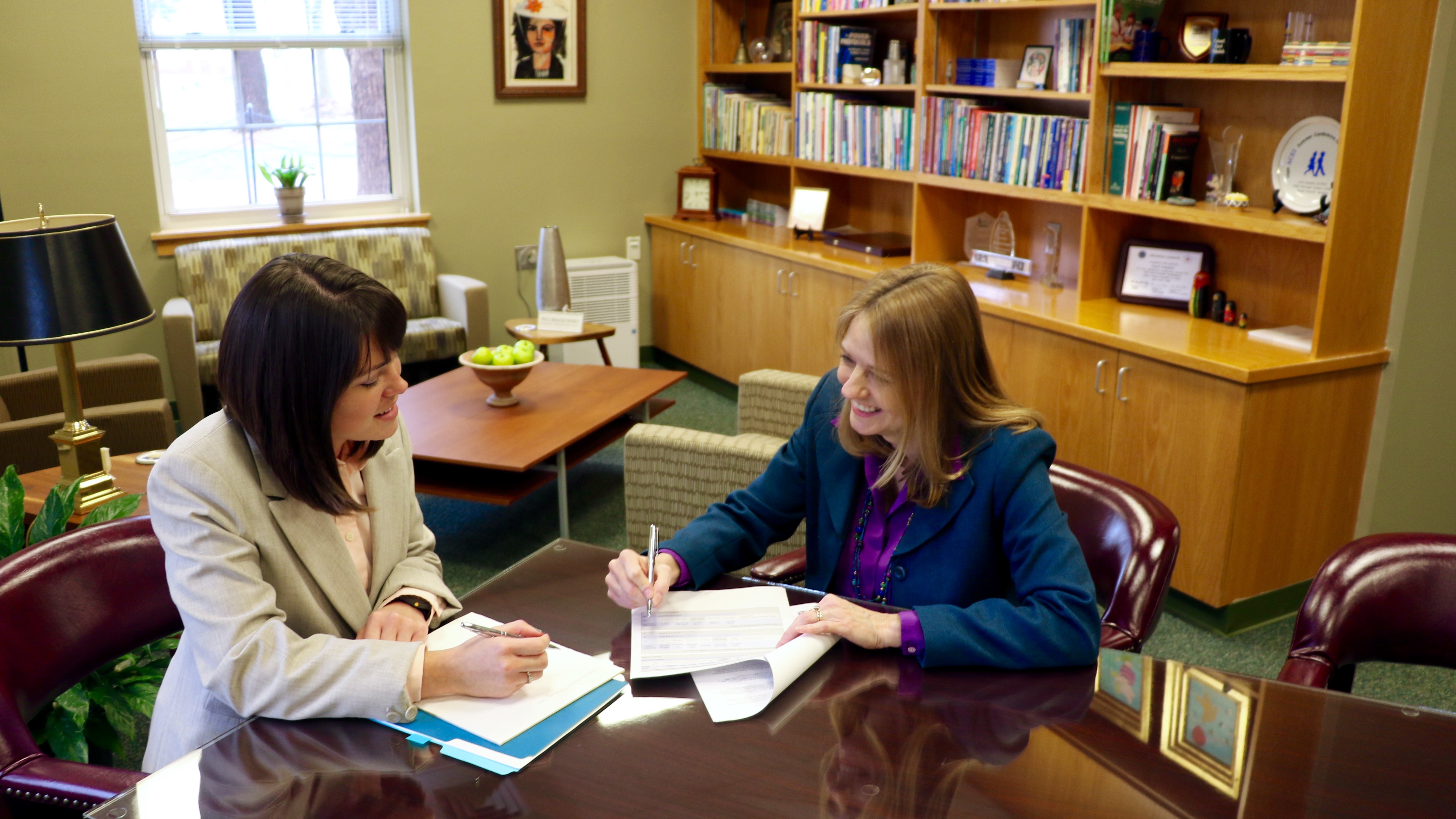 A CEHD advisor meets with a student in her office to discuss program offerings and course schedules.