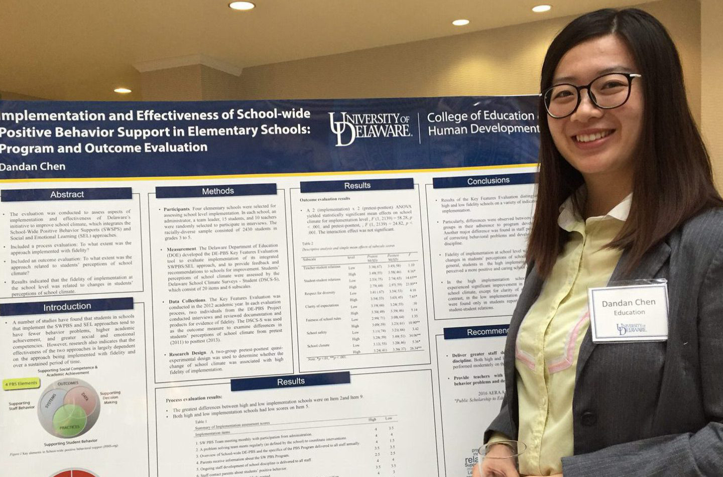 Graduate student Dandan Chen stands next to her research poster