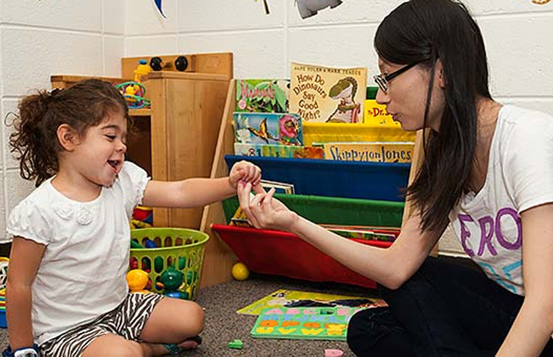 Doctoral student engages in research activity with a child