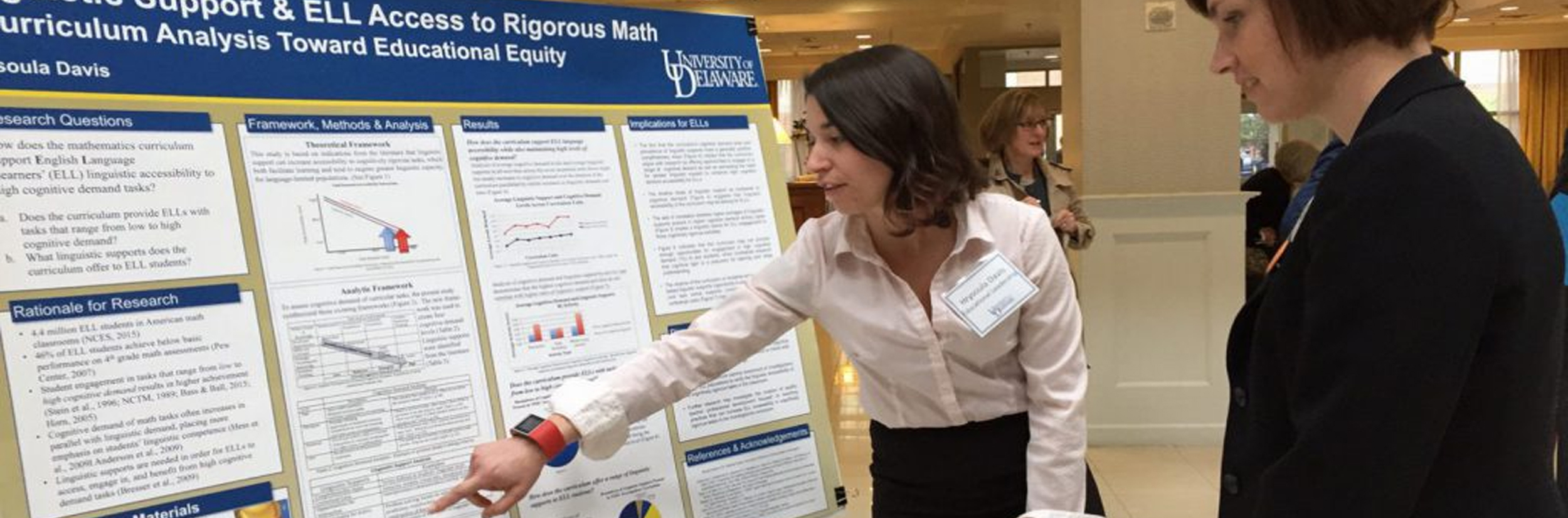 Doctoral student shows her research poster to a woman