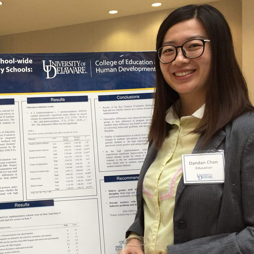 Graduate student Dandan Chen stands next to her research poster