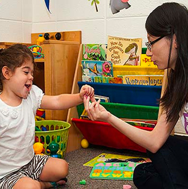 Doctoral student engages in research activity with a child