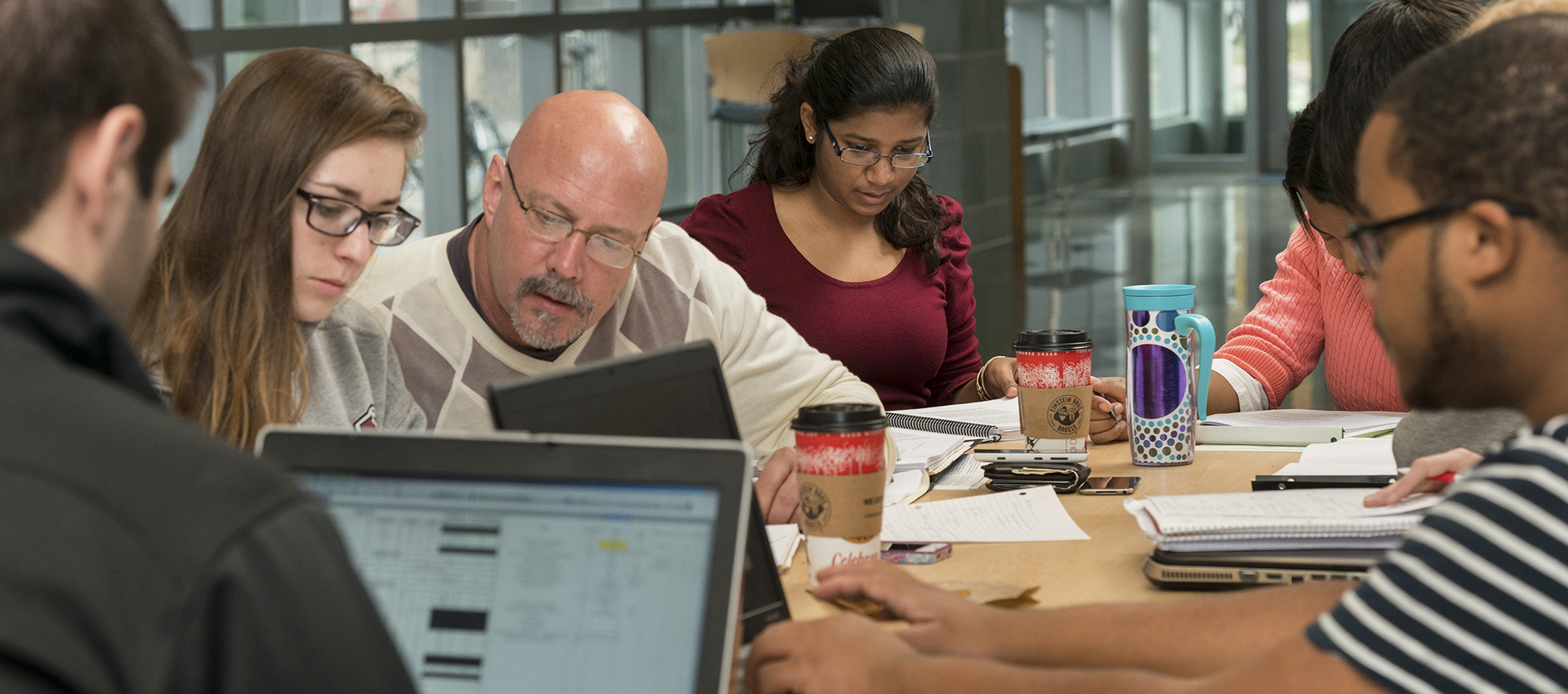Students study around a table.