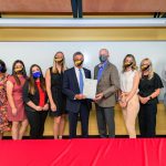 UD teacher residents accept teaching positions in Red Clay Consolidated School District during its Teacher Signing Day. From left to right: Krissy Najera (director of DCTE), Jamie Bailey (director of UD’s Teacher Residency program), Mariela Lomeli, Alexa Cruz, Meghan Purcell (UD residents), Governor John Carney, CEHD dean Gary T. Henry, Meghan Salter, Claire Bennett, and Clark Scott (UD residents).